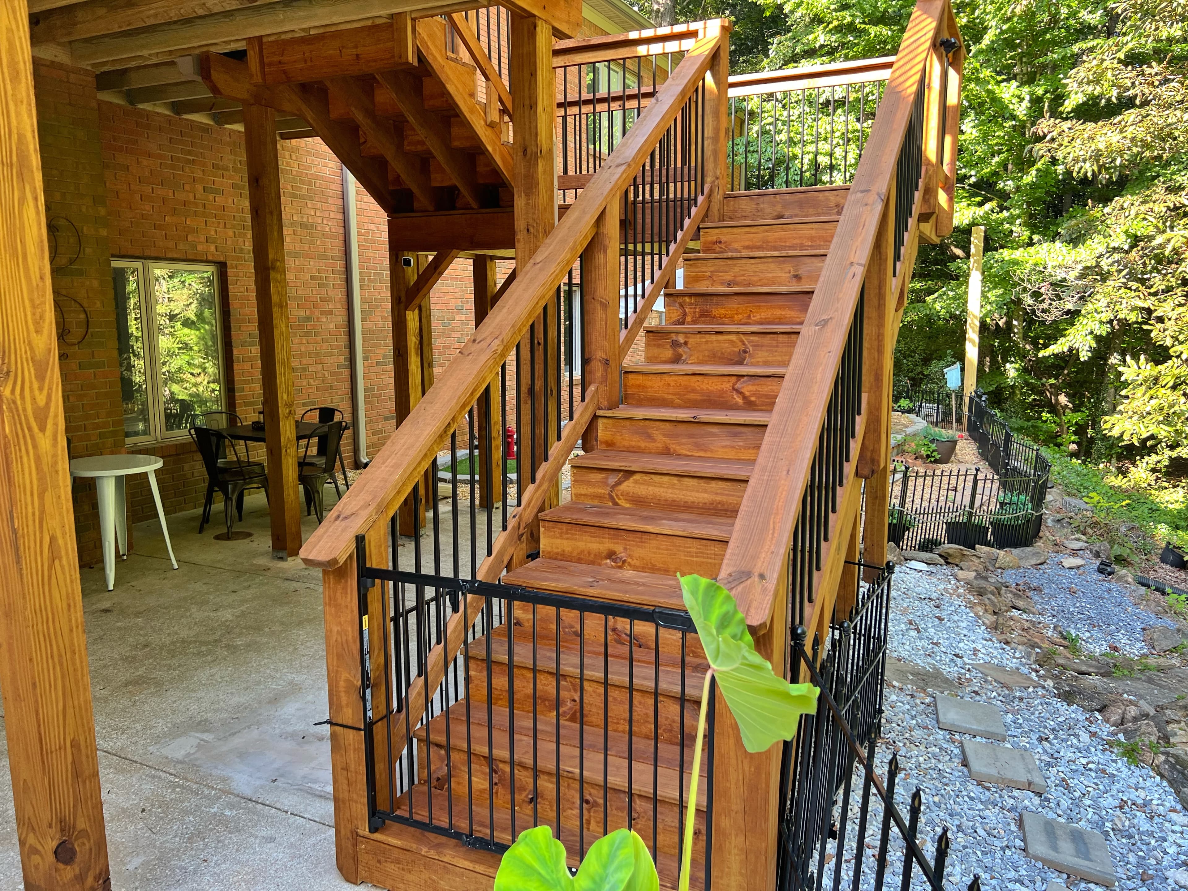 Beautifully stained deck stairs with iron balusters